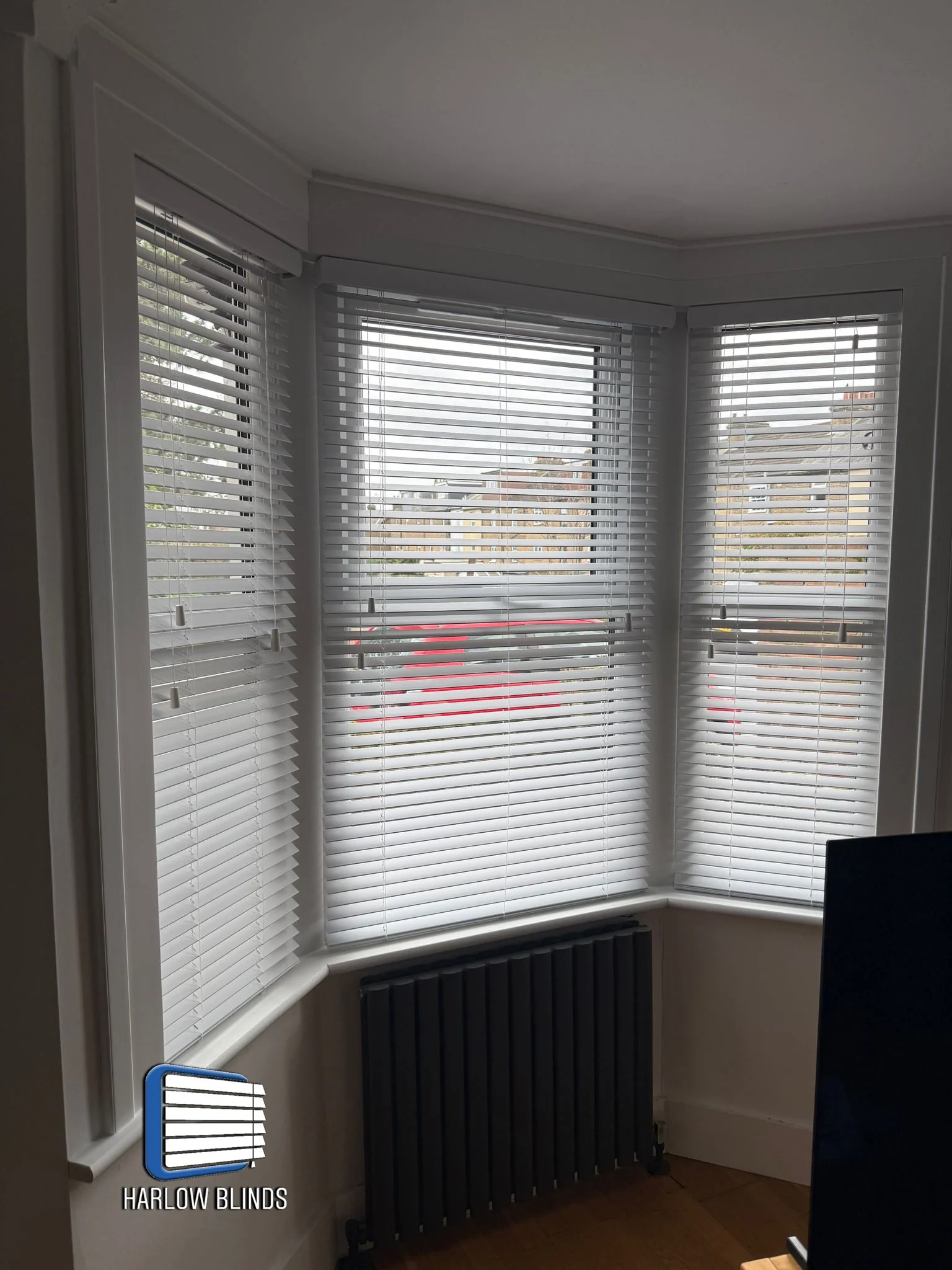 35mm faux wood Venetian blinds fitted in a bay window in Hoddesdon